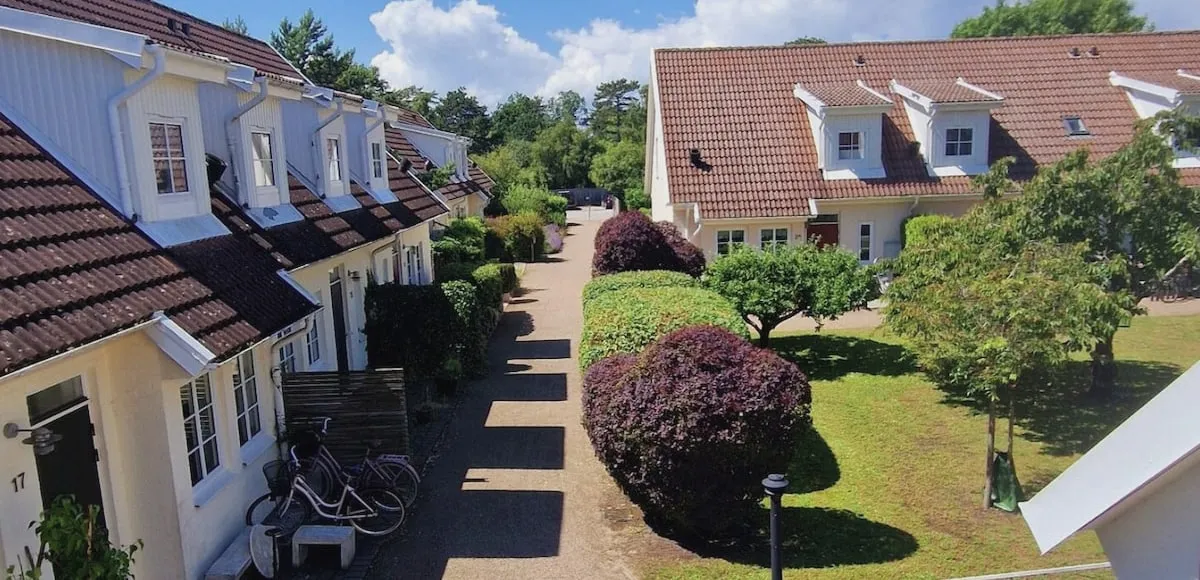 View from Kustlägenheten’s patio — white houses with tiled roofs along the lane through the Falsterbo neighbourhood